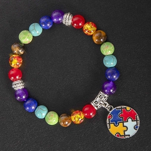 Close-up of rainbow beaded yoga bracelet with autism awareness puzzle heart charm