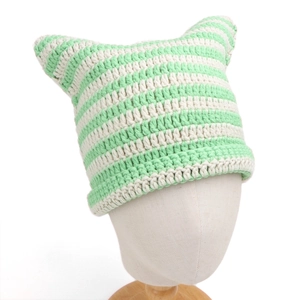 Detailed knit texture of a green and white striped cat ear beanie with crochet details