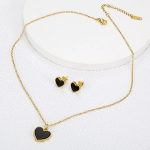 Elegant gold titanium jewelry set with black heart pendant and matching stud earrings