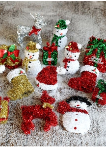 Glittery Christmas ornaments with snowman and reindeer shapes on artificial snow