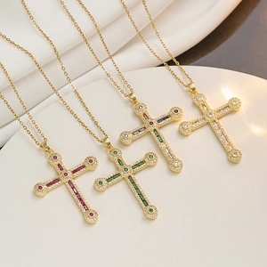 Hip hop cross necklaces with colorful rhinestones on gold chains over silk fabric