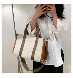 Detail of canvas tote bag with contrast leather trim and detachable shoulder strap