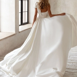Elegante Rückansicht eines weißen Satin-Brautkleids mit Stickerei und langer Schleppe