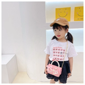 Détail du sac en tweed rose pour filles avec poignée en perles et nœud floral chic