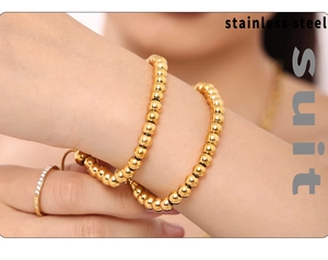 Close-up of a 4mm gold-plated stainless steel bead bracelet and ring set on wrist