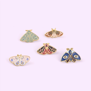 Set of five mystical butterfly enamel pins with moon and star patterns on purple background
