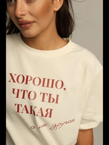 Detail of white cotton T-shirt featuring red Cyrillic text print on the chest