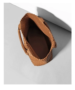 Close-up of brown woven leather tote showing spacious interior and texture