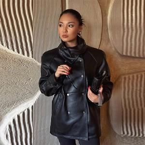 Détail d'une veste chic en similicuir noir avec col montant et cordon de serrage à la taille