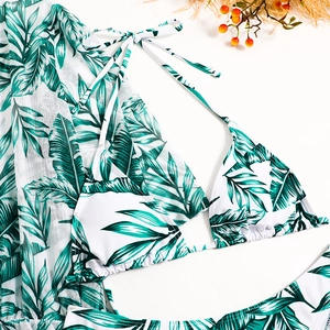 Flat lay of tropical palm leaf print 3-piece bikini set with sheer mesh long sleeve cover-up