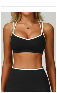 Detailed view of black sports bra with white contrast piping and double straps