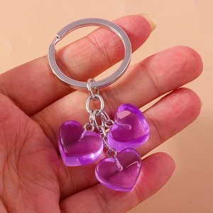Detail view of a silver keyring featuring three translucent purple jelly heart pendants