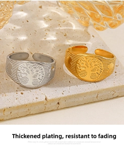 Close-up of 18k gold and silver Tree of Life rings with granular texture on stone tray