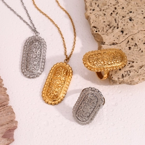 Detail of vintage 18K gold and silver necklaces with floral embossing on wet stone surface