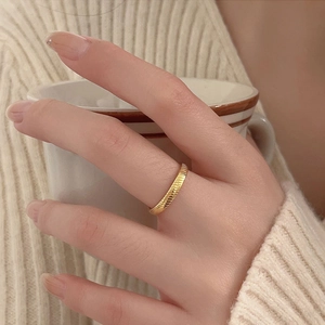 Close-up of minimalist gold plated 925 silver ring with textured twill pattern on finger