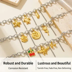 Macro detail of stainless steel charm bracelet featuring gold sea turtle and shell motifs