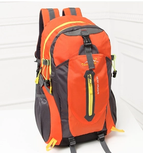 Close-up of orange hiking backpack with yellow zippers and vertical zip pocket