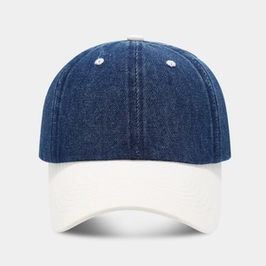 Detail of two-tone denim baseball cap featuring navy blue panels and a white brim