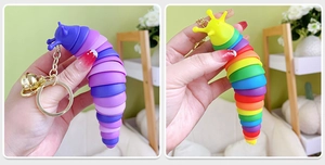 Detail showing flexible rainbow and blue gradient slug fidget toy keychains with bells