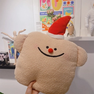 Detail eines weihnachtlichen Plüschkissens aus weichem Sherpa mit festlicher roter Mütze