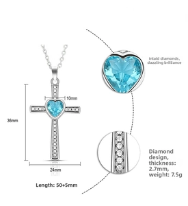Detail view of cross necklace featuring blue heart gemstone and white zircon stones