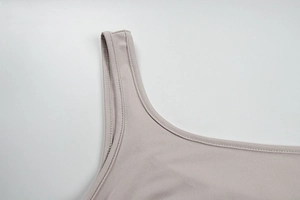 Gros plan sur la couture double d'une bretelle de robe en maille gris clair