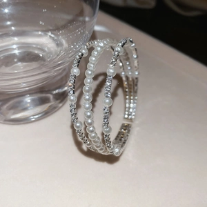 Macro detail of silver layered bangle with white pearls and sparkling rhinestones