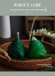 Detailed view of zongzi-shaped scented candles with leaf texture and cotton wick in a tray