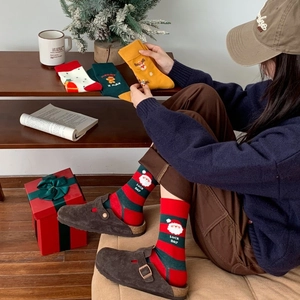 Cozy Christmas themed cotton socks with Santa and reindeer patterns in holiday colors