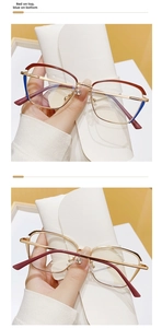 Detail of cat-eye glasses with red and blue frame and golden metal temples