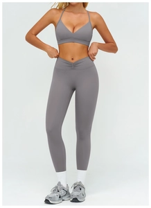 Dettaglio dei leggings da yoga a vita alta con fascia a V incrociata in grigio scuro