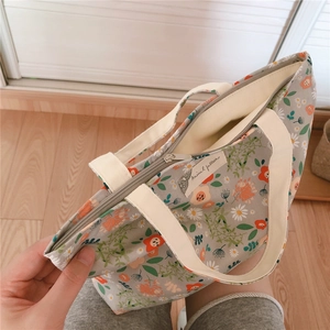 Detailed view of floral cotton tote bag with zipper closure and white ribbon handles