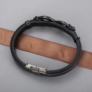Macro detail of black braided leather men's bracelet with gray matte metal magnetic buckle