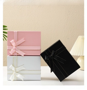 Detail of premium matte folding gift boxes in pink, white and black with silk ribbon bows