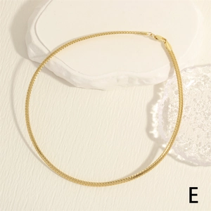 Macro detail of high-polish 18K gold-plated snake chain necklace with lobster clasp