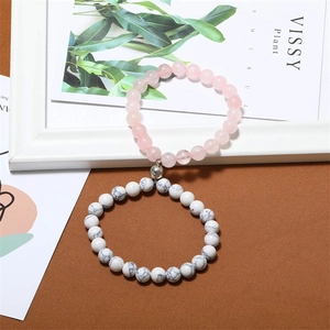 Detail of magnetic stone bracelets for couples featuring pink rose quartz and white turquoise