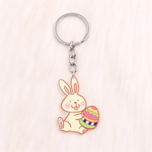 Close-up of Easter bunny keychain holding a colorful egg on a soft plush background
