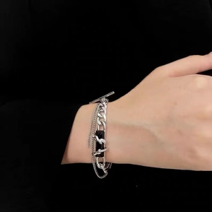 Silver multilayer chain bracelet with black stone and T-bar toggle clasp on model wrist