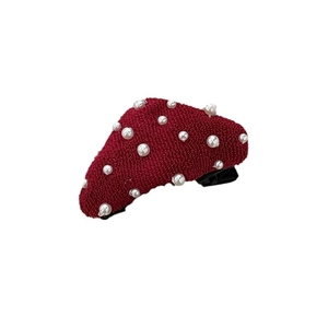 Cute dark red plush triangle hair clip with white pearls on a minimalist white background