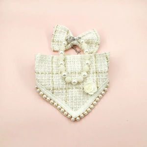 Detail of cream tweed pet bandana with pearl collar and rose flower on pink background