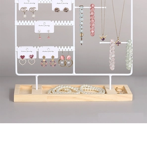 Detail of white iron jewelry rack with wooden base and tiered earring hooks