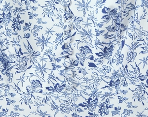 Close-up of white floral dress featuring blue print and matching fabric-covered buttons
