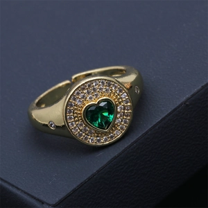 Détail de la bague dorée réglable avec zircon vert en forme de cœur et pavé de cristaux