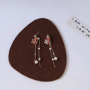 Detail view of long tassel Christmas earrings with gift box charm and white pearls