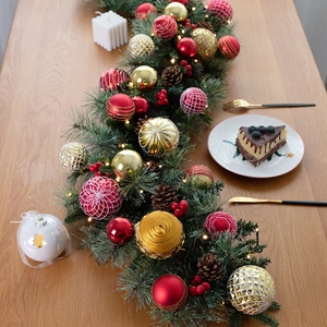 135cm pre-lit Christmas garland with red gold baubles and pine cones on a wooden table
