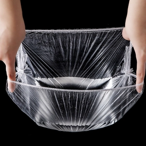 Stretchy transparent PE food covers with elastic bands shown expanded against black background