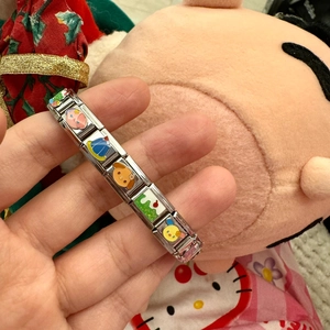 Detailed close-up of stainless steel Italian modular bracelet with colorful enamel charms