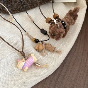 Detailed shot of cute plush puppy and resin kitten charms on adjustable cord necklaces