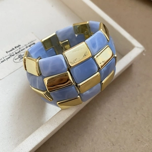 Macro shot of Sky Blue resin tiles and Golden mirror metal blocks on a retro bracelet