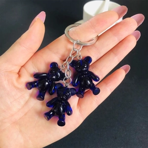 Detail of three blue translucent gummy bear charms on a metallic keychain